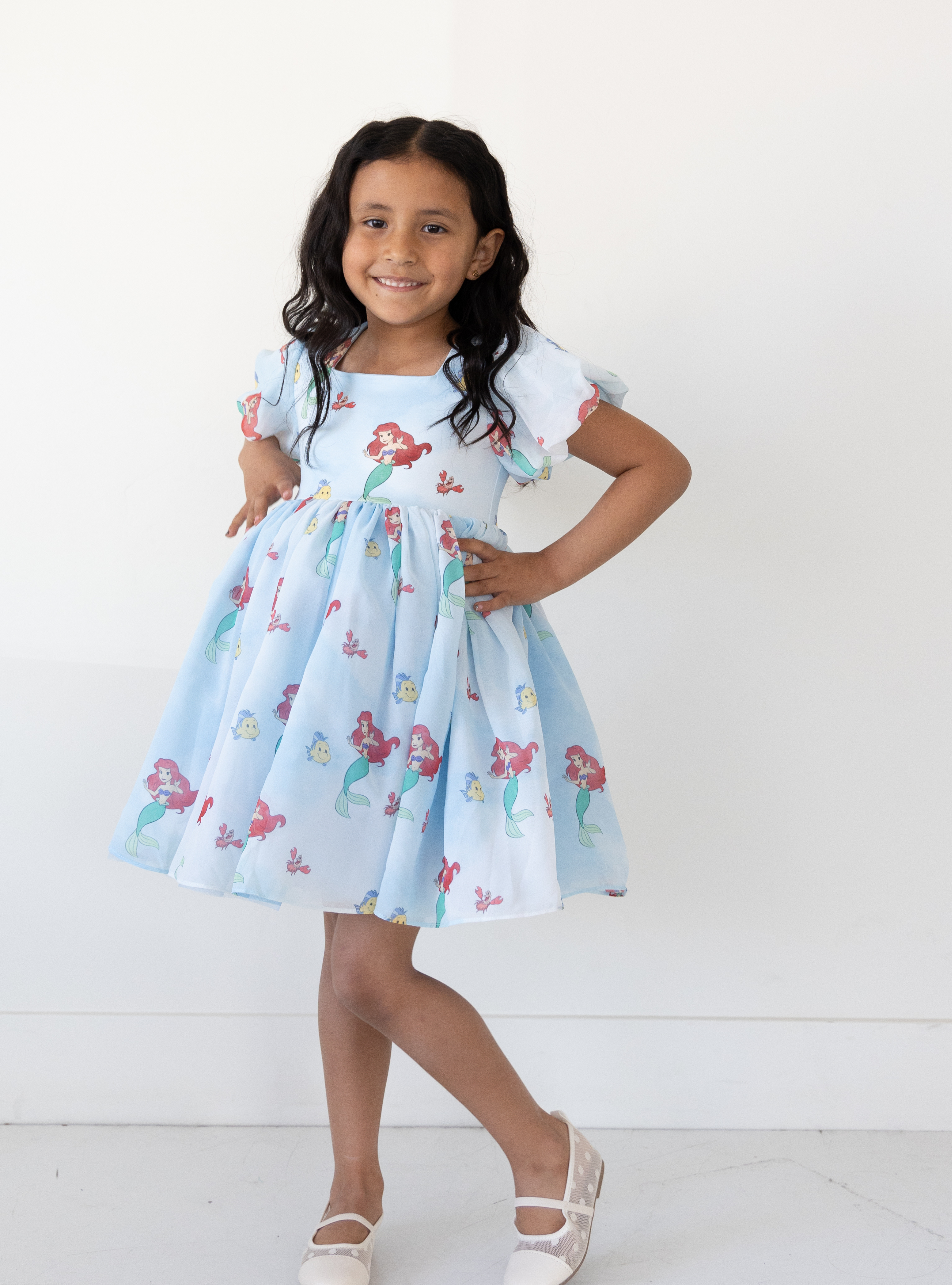 Disney and Taylor Joelle branded Ariel dress with an Ariel, Flounder, and Sebastian print all around. This dress has puff sleeves, and a high waited puff chiffon skirt.