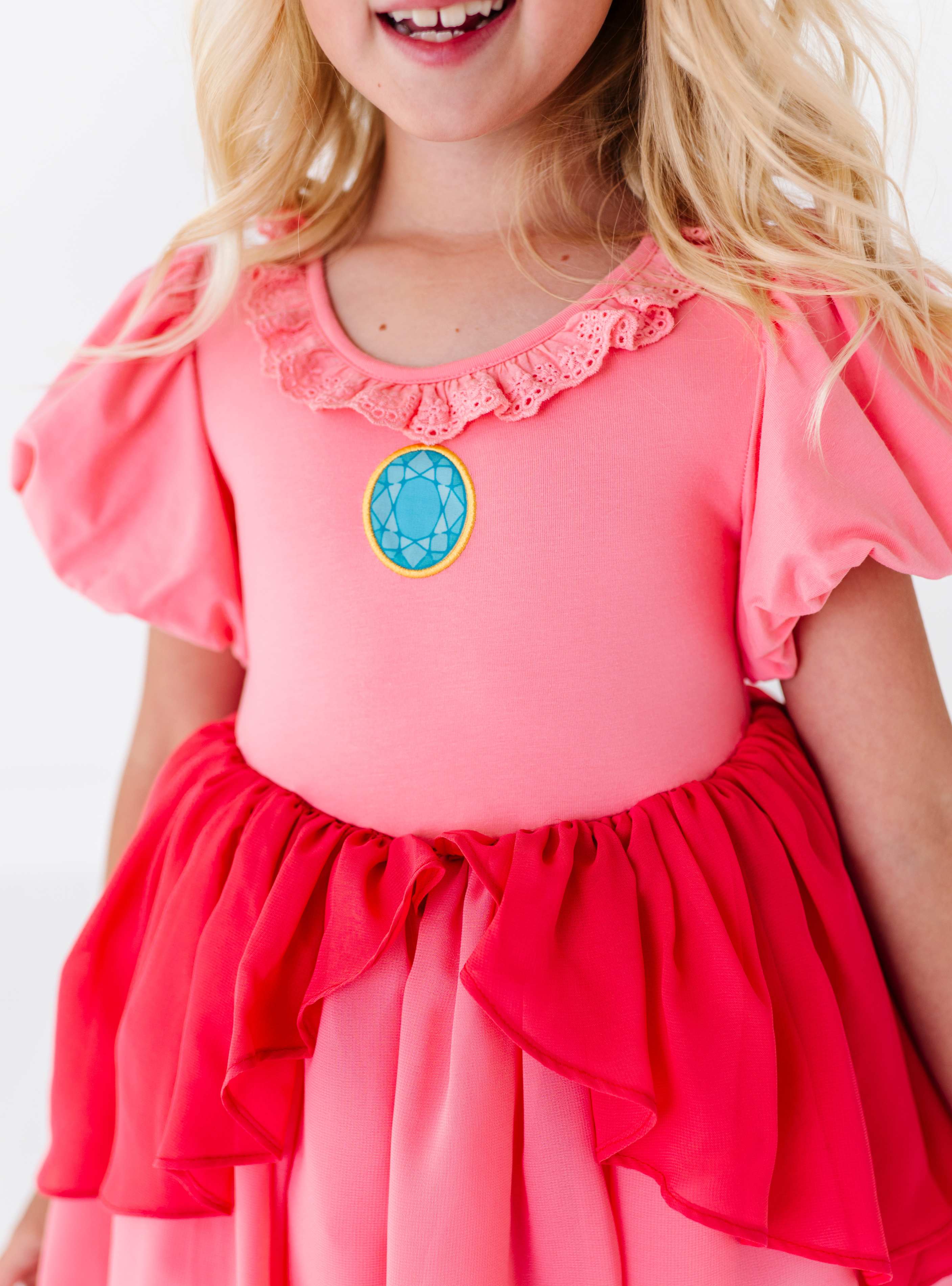 It features a gem detail, along with a playful ruffle on the neckline!