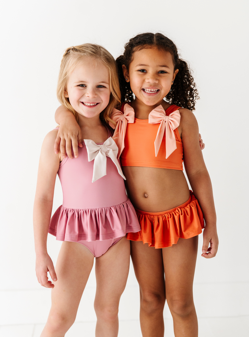 Coordinate the Blushing Bow One Piece with the Beach Babe Two Piece for extra cuteness at the pool!