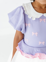 What could be cuter than a white ruffled collar, puffed sleeves, and sweet pink bows?!