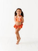 The Beach Babe two-piece is perfect for going into summer with style! Complete with all the cute ruffles and bows, you and you're little one will love this style!