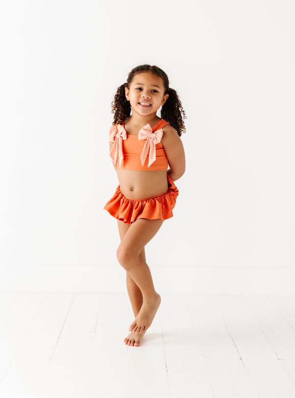 The Beach Babe two-piece is perfect for going into summer with style! Complete with all the cute ruffles and bows, you and you're little one will love this style!