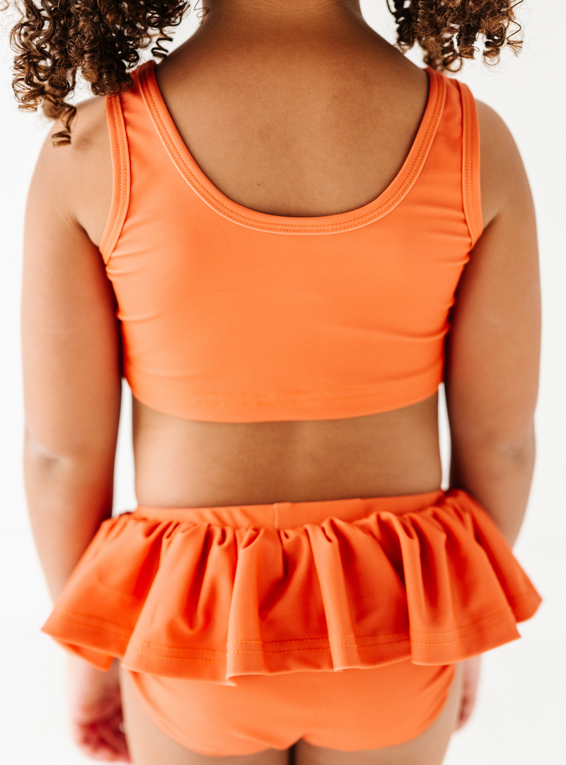 Featuring a cute orange color, and ruffles on the bottom, how could you not love this two piece?!
