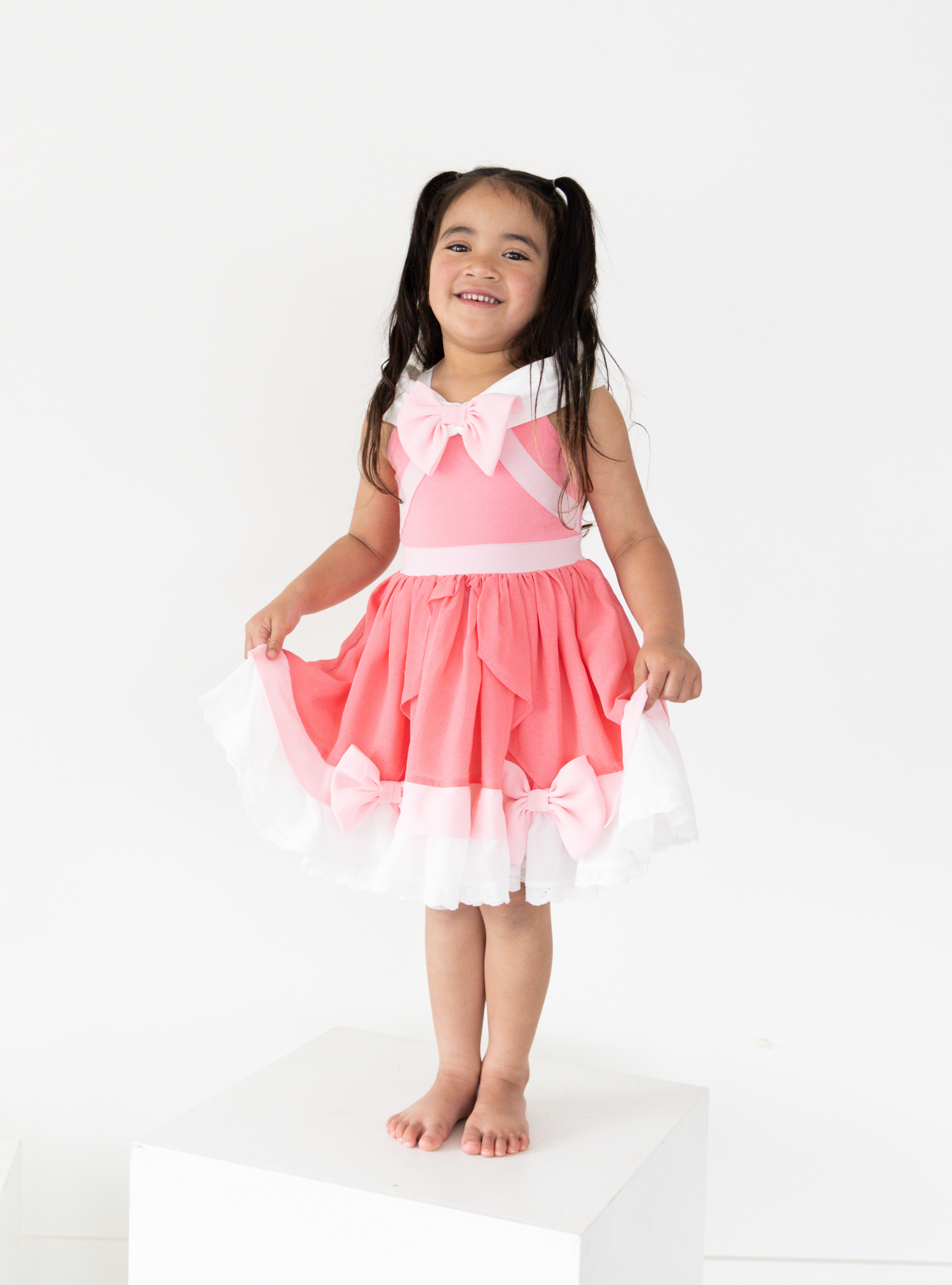 Disney and Taylor Joelle branded Pink Cinderella Dress. This dress is detailed with off the shoulder sleeves, bows, and different pink and white detailing.