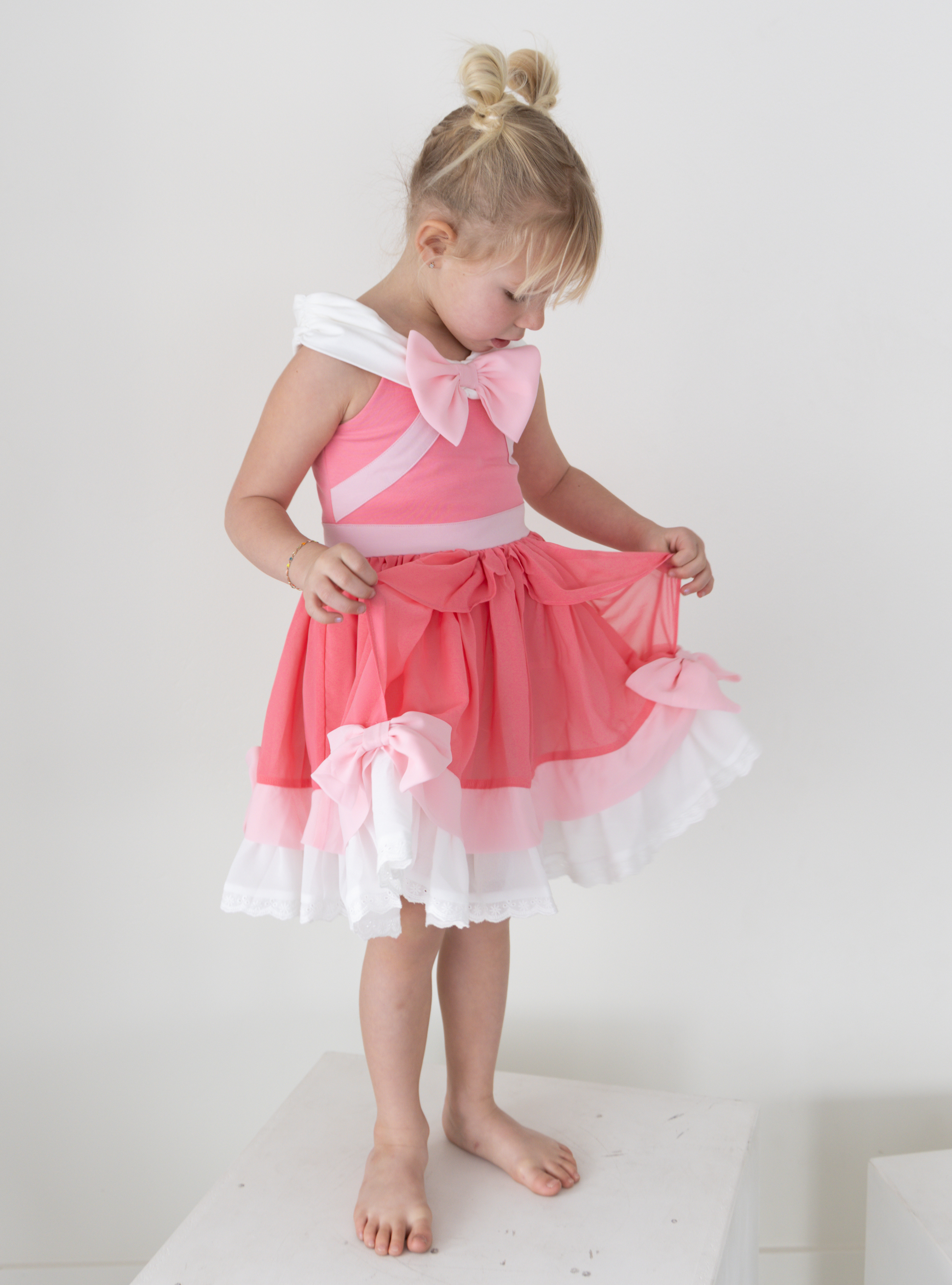 Disney and Taylor Joelle branded Pink Cinderella Dress. This dress is detailed with off the shoulder sleeves, bows, and different pink and white detailing.