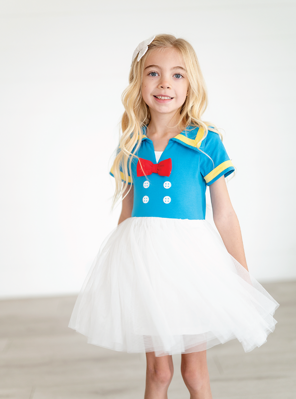 The Blue Sailor Dress is a Donald Duck-inspired dress, featuring cute faux buttons and a red bow!