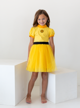 The superstar dress is a yellow goofy Powerline inspired dress. it has a black waistline and a symbol on the front. 