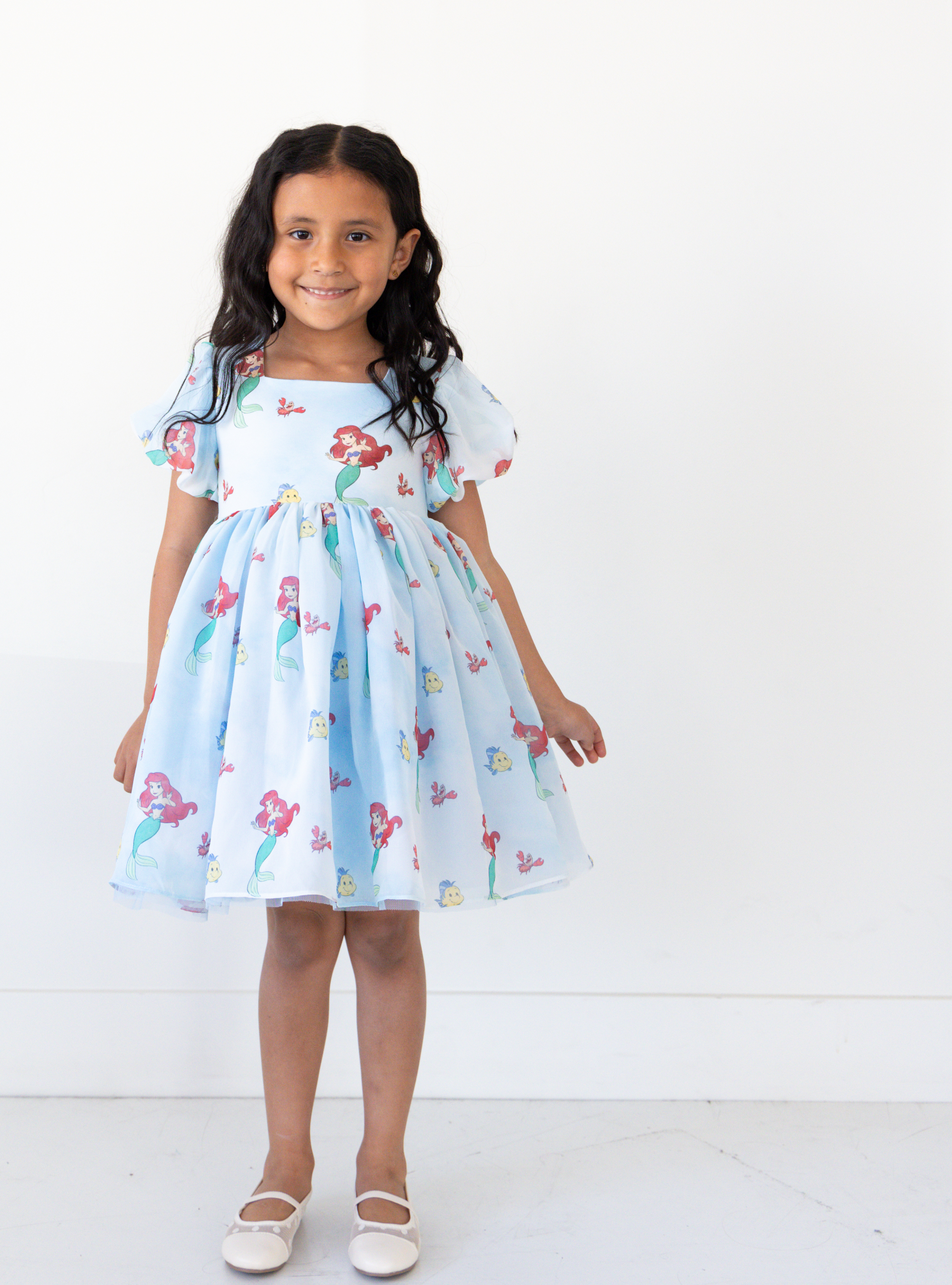Disney and Taylor Joelle branded Ariel dress with an Ariel, Flounder, and Sebastian print all around. This dress has puff sleeves, and a high waited puff chiffon skirt.