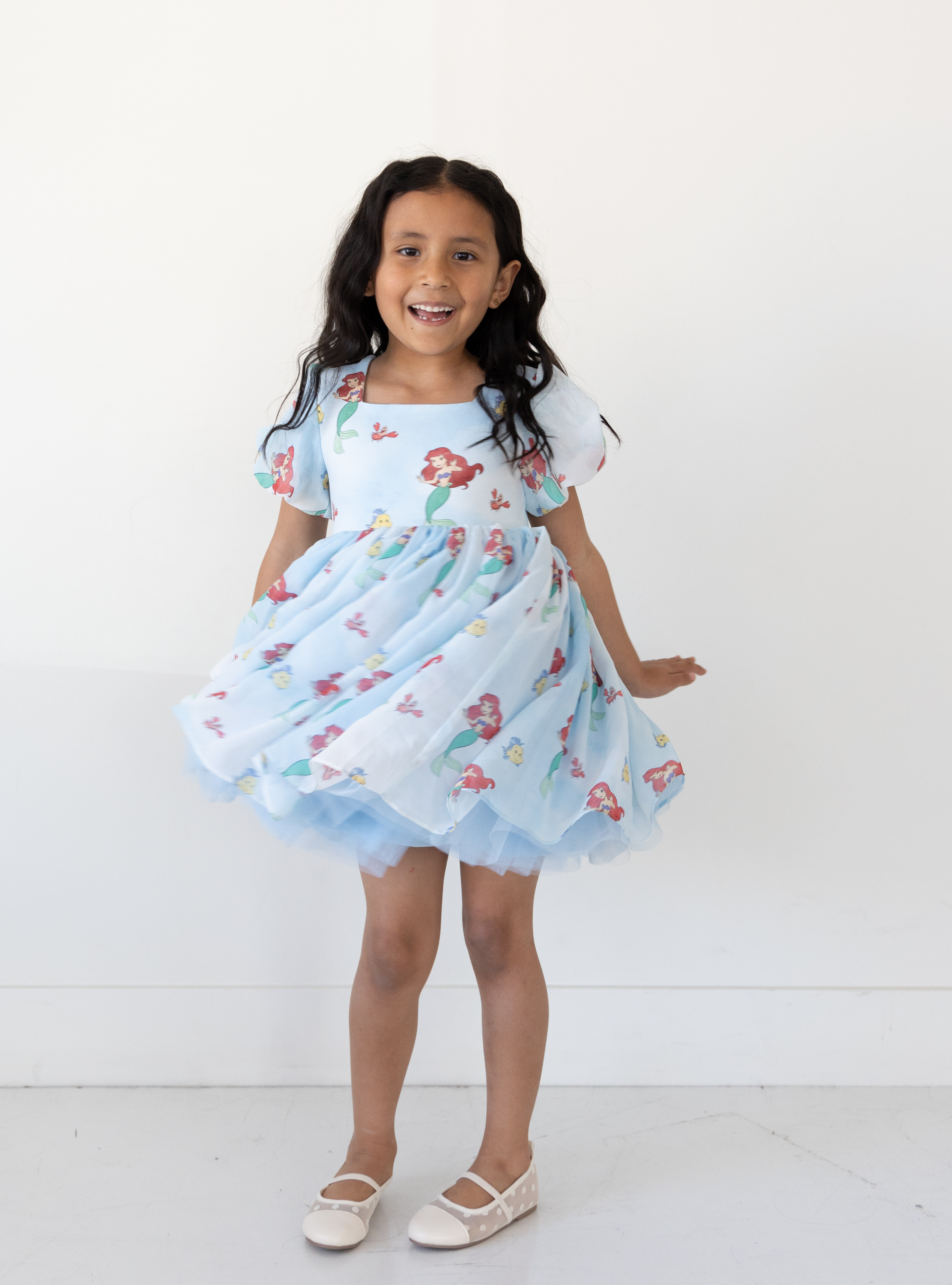 Disney and Taylor Joelle branded Ariel dress with an Ariel, Flounder, and Sebastian print all around. This dress has puff sleeves, and a high waited puff chiffon skirt.