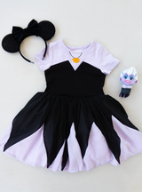 Features a light purple color on the top and bottom, with black on the torso and top half of the skirt.