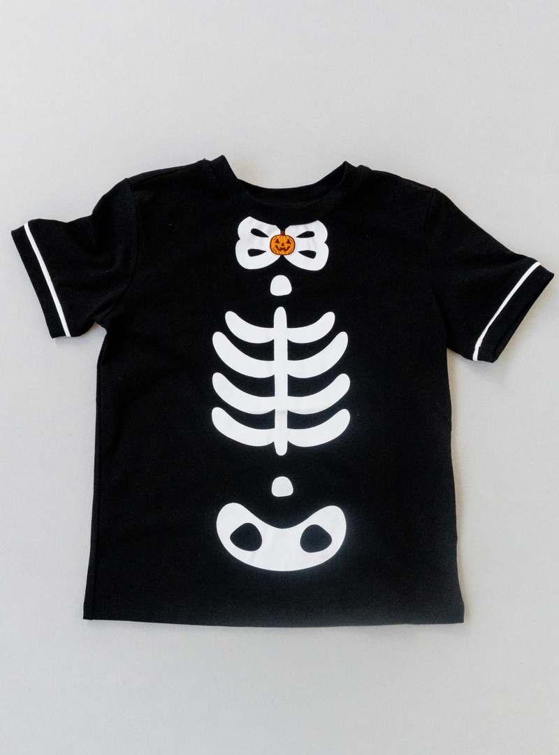 Features a fun skeleton design on the front as well as a tiny pumpkin design near the neckline and small white stripes on the sleeves.